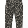 Black floral print tapered pants for girls aged 5 to 6 years with white flower patterns