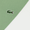 Folded sage green Lacoste polo shirt with three-button placket and embroidered crocodile logo