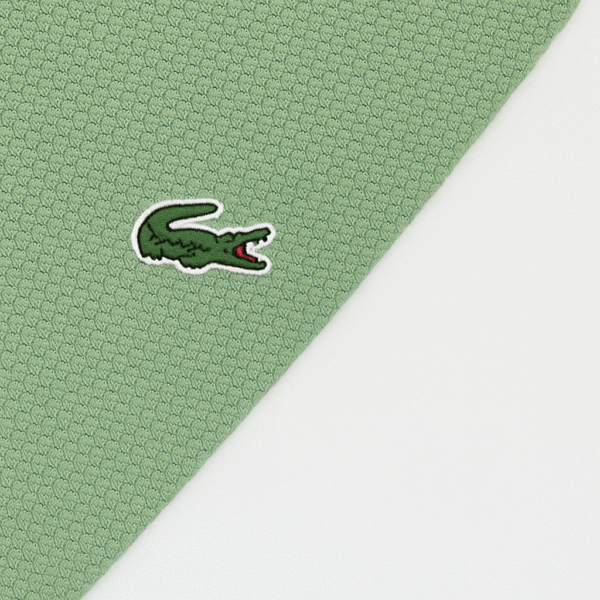 Folded sage green Lacoste polo shirt with three-button placket and embroidered crocodile logo