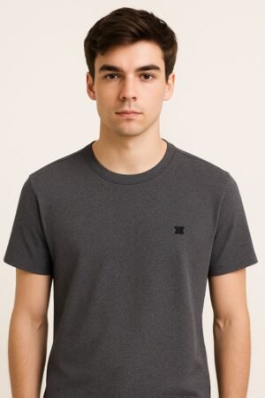Close-up of folded heather charcoal gray t-shirt with black embroidered DC logo on the corner