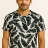 Man wearing a high-quality round neck t-shirt with an all-over black leaf print on an off-white background