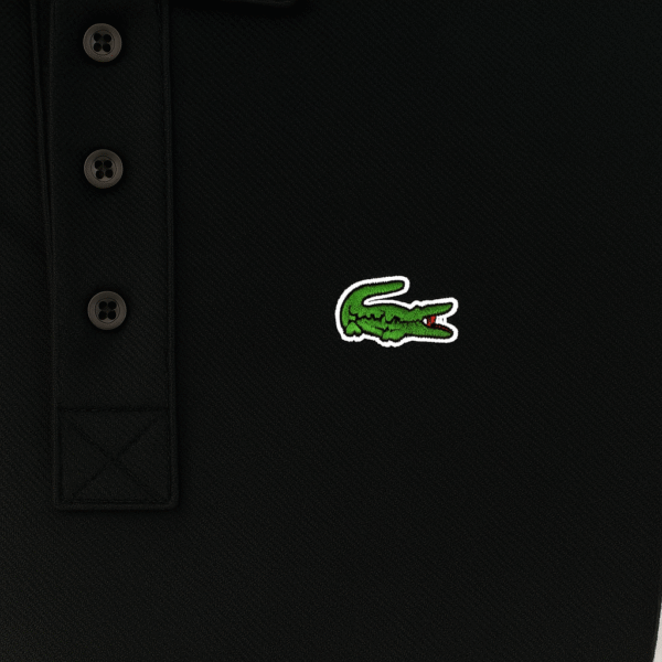 Folded black Lacoste polo shirt with green crocodile logo and white label text