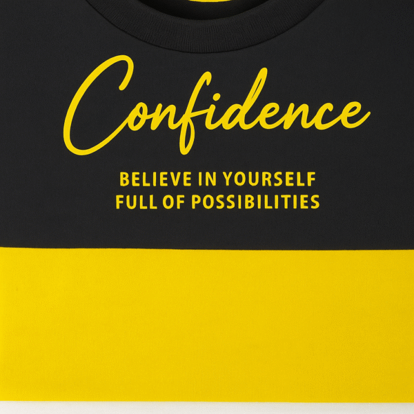 Kids color-block T-shirt in black and yellow with “Confidence” text printed on front