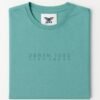 Man wearing a teal green T-shirt with minimalist “DENIM • 1998” text across the chest