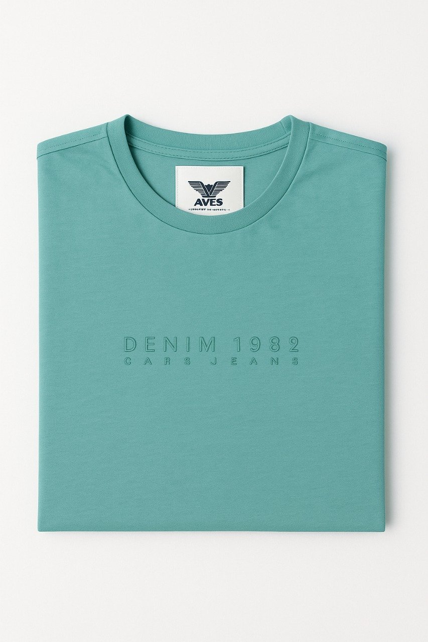 Man wearing a teal green T-shirt with minimalist “DENIM • 1998” text across the chest