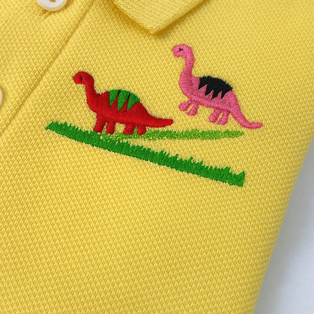 Folded yellow kids polo shirt with dinosaur embroidery and KidsClub branding