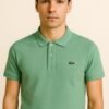Folded sage green Lacoste polo shirt with three-button placket and embroidered crocodile logo