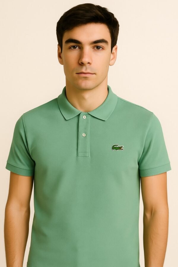 Folded sage green Lacoste polo shirt with three-button placket and embroidered crocodile logo