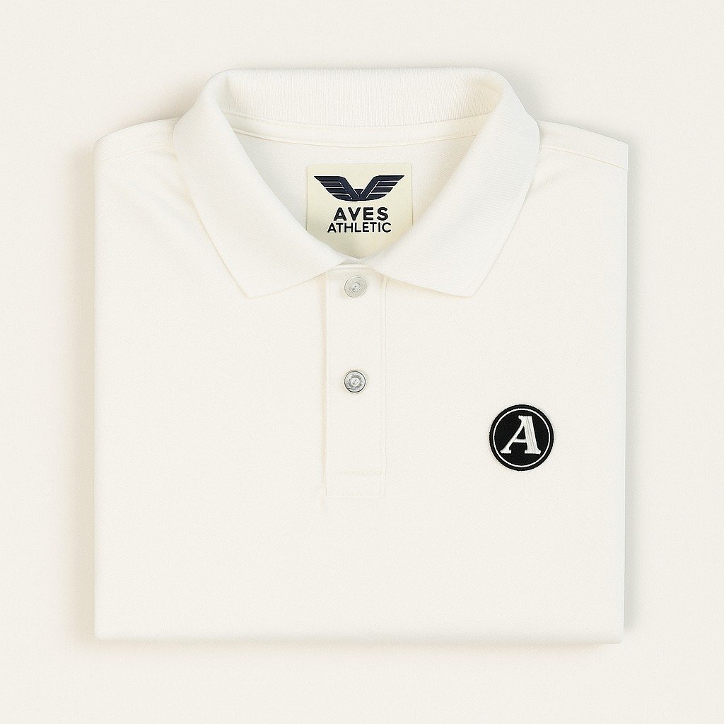 Man wearing an off-white polo shirt with a small black circular “A” logo patch on the chest
