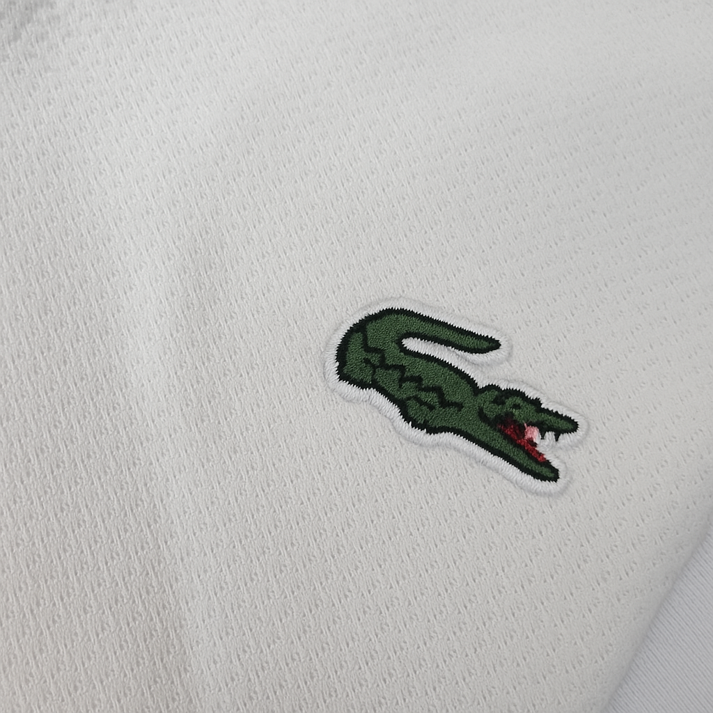 Folded Lacoste white polo shirt with embroidered crocodile logo