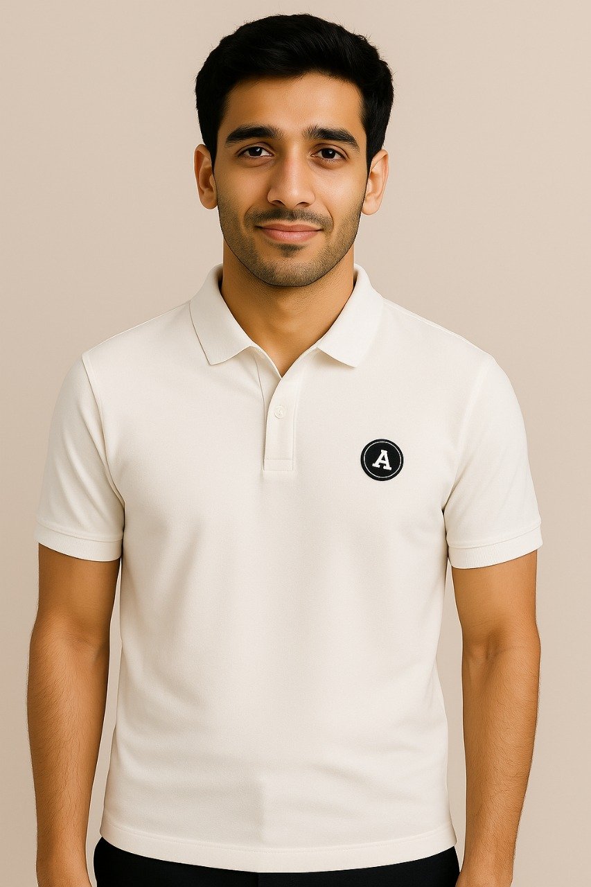 Man wearing an off-white polo shirt with a small black circular “A” logo patch on the chest