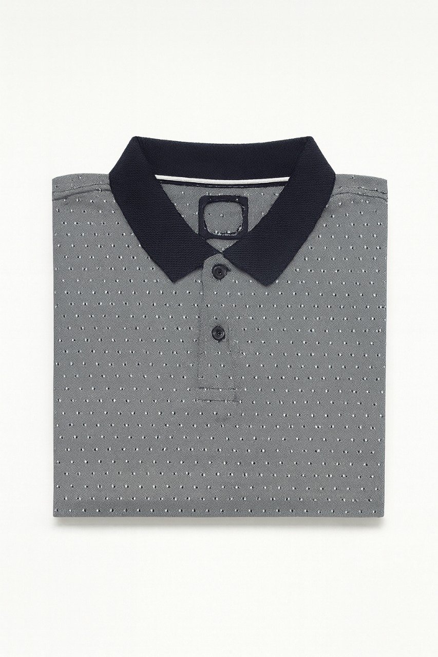 Folded grey polo shirt with small white geometric dot pattern and navy blue collar.