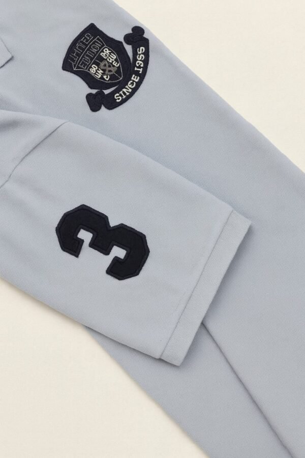 Folded light blue polo shirt with embroidered "Limited Edition Since 1968" crest on chest