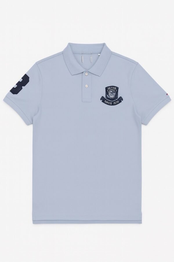 light blue polo shirt with embroidered "Limited Edition Since 1968" crest on chest.