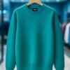 Teal Green Crew Neck Sweatshirt – Casual Unisex Pullover for Everyday Wear Teal green plain crew neck sweatshirt on wooden hanger in modern clothing store.
