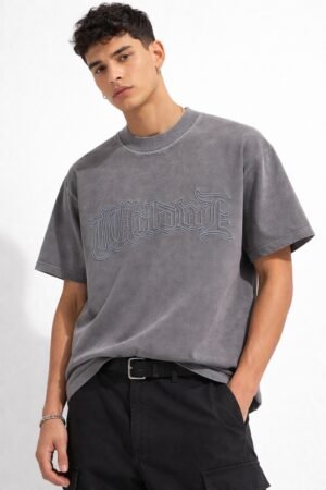 Male model wearing a dark grey oversized half-sleeve t-shirt with embossed “Worldwide” text graphic on the front.